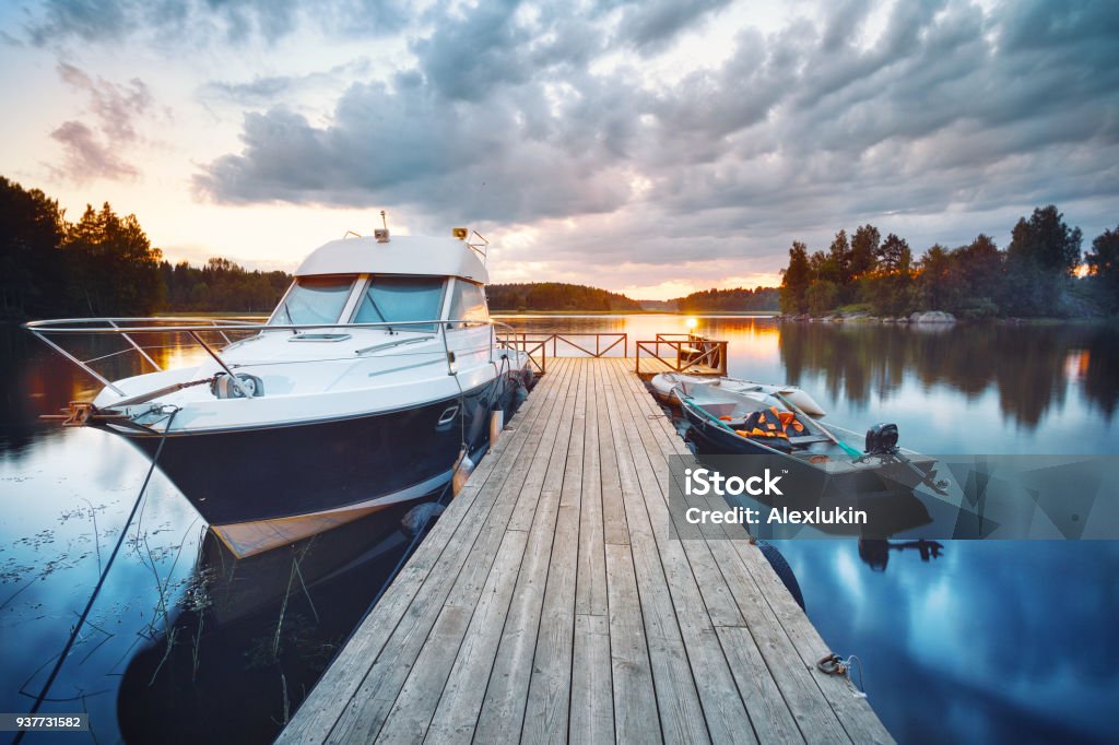 Wooden pier with boat Wooden pier with boat at sunset Nautical Vessel Stock Photo