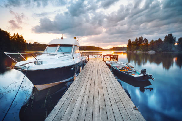 Wooden pier with boat Wooden pier with boat at sunset aquatic sport photos stock pictures, royalty-free photos & images