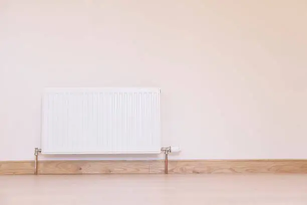 One white radiator inside home neutral oak interior large wall