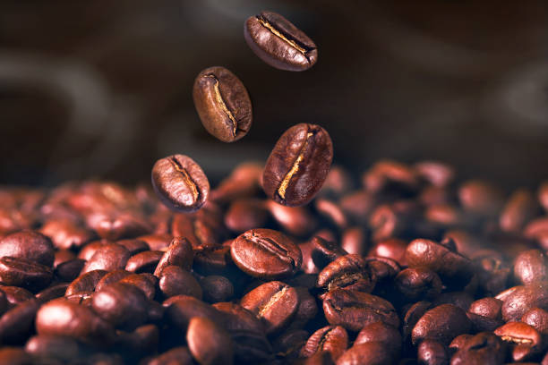 istock Macro of falling coffee bean with smoke on brown background 937745982