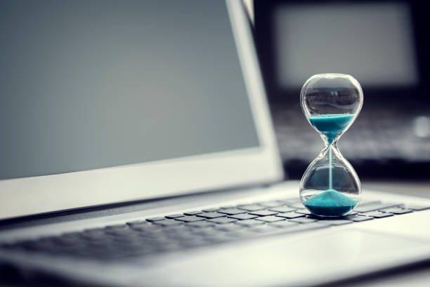 hourglass on laptop computer concept for time management - deadline imagens e fotografias de stock