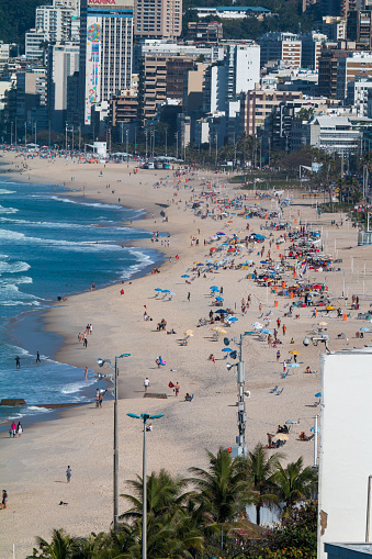 Beachgoers in Ipanema with hotels and apartments lining the famous beach