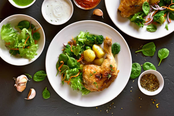 istock Baked chicken leg with potato and green salad 937754384