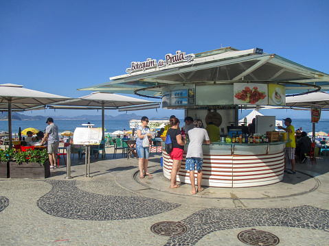 Holidaymakers around a sidwalk cafe cum beach bar on Copacabana Beach in Rio