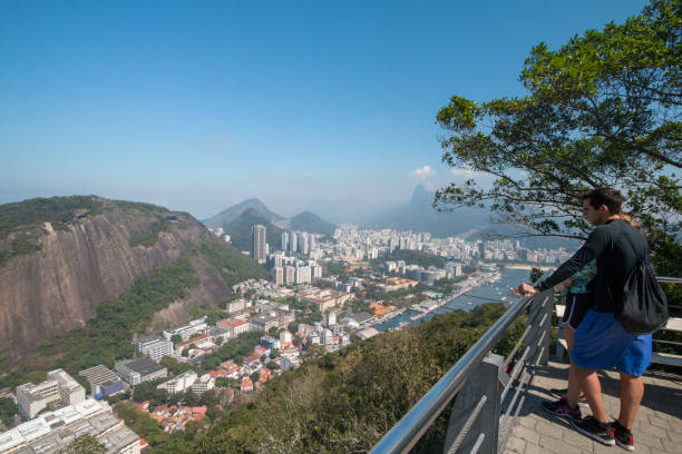 A young Caucasian couple enjoy the viewpoint over Rio de Janeiro from Morro da Urca, a hill near Sugarloaf Mountain