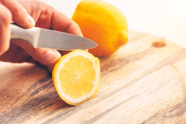 istock Cook's hand slices a lemon on a cutting board 937784462