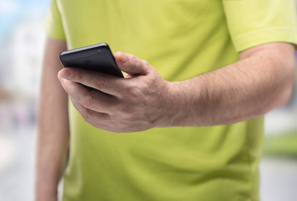 istock man on street with black smartphone in his hand 937788540