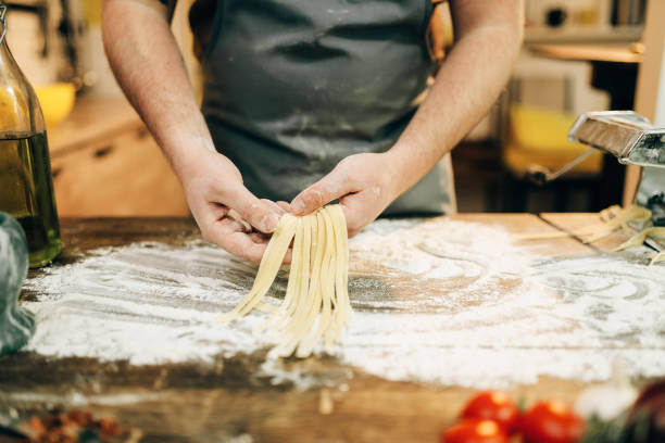 istock Male chef cooking dough and prepares pasta machine 937795698