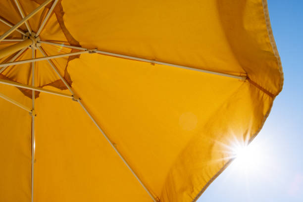 istock Yellow umbrella and rays of sun 937796216