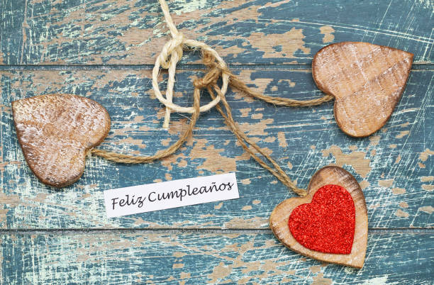 istock Feliz Cumpleanos (Happy Birthday in Spanish) with wooden hearts on rustic surface 937796398