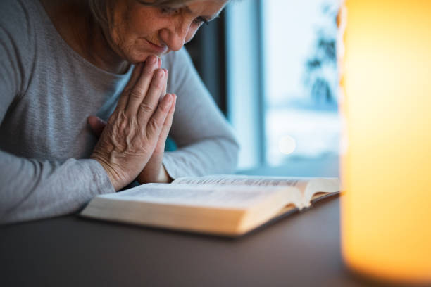 istock A senior woman praying at home. 937796806