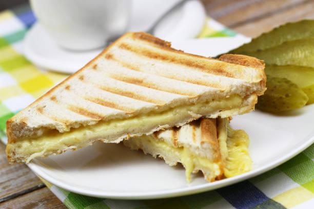 istock Two pieces of toasts with melted cheese on white plate, closeup 937800310