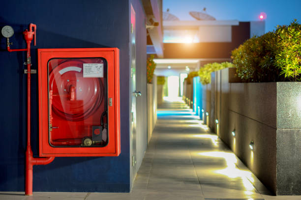 brandschutzkonzept, feuerlöscher und feuerwehrschlauch reel in öffentliche gebäude korridor - glass sign office security stock-fotos und bilder