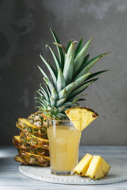 istock Pineapple fresh juice in glass on a wooden table 937822522