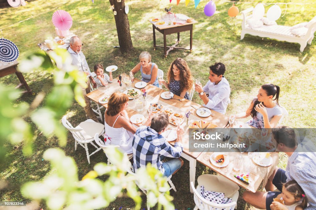 Celebración familiar o una fiesta en el jardín exterior en el patio trasero. - Foto de stock de Familia libre de derechos