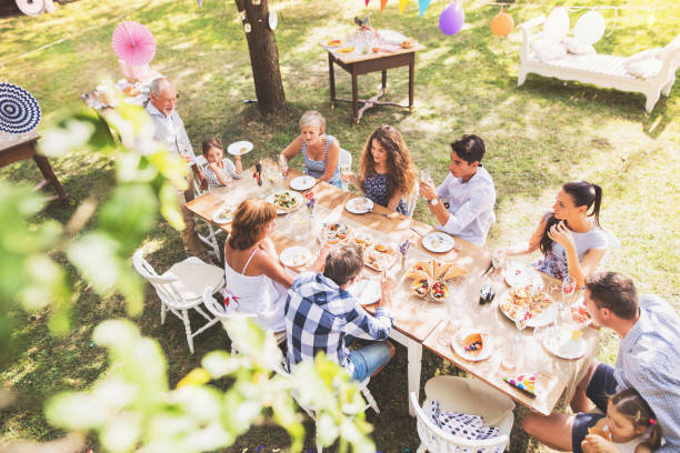 Family celebration or a garden party outside in the backyard. Family celebration outside in the backyard. Big garden party. High angle view. formal garden stock pictures, royalty-free photos & images