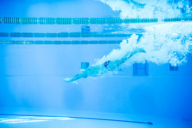 istock Senior man jumping in the swimming pool. 937829736