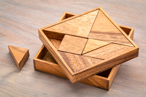Tangram, a traditional Chinese Puzzle Game made of different wood parts to build abstract figures from them