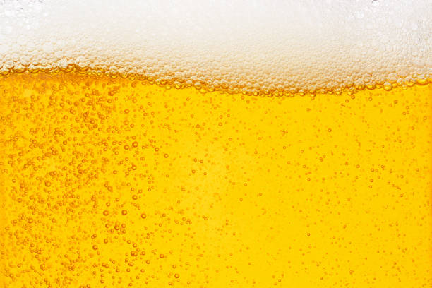 Pouring beer with bubble froth in glass for background on front view wave curve shape