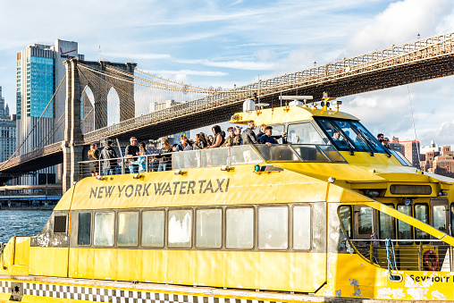 Brooklyn, USA - October 28, 2017: Outside outdoors in NYC New York City Brooklyn Bridge Park with many crowd of people on water taxi yellow ferry cruise tour boat