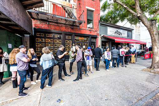 Brooklyn, USA - October 28, 2017: Long line queue of people crowd waiting for famous restaurant food called Juliana's Pizza