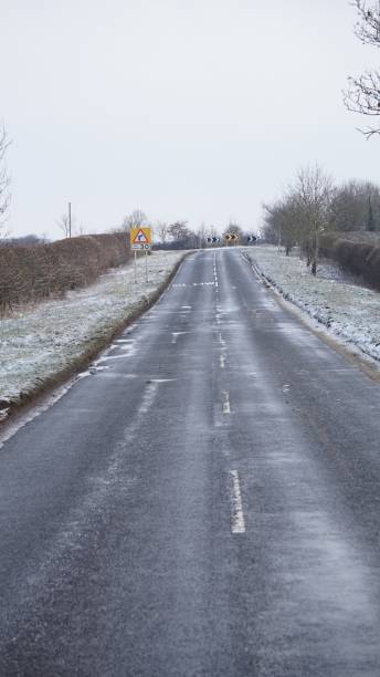 istock Country road and snow covered grass verges. 937836680