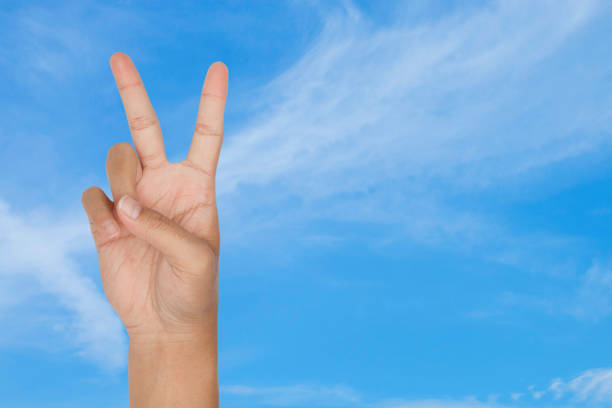 istock symbol of victory by hand with blue sky background 937836956