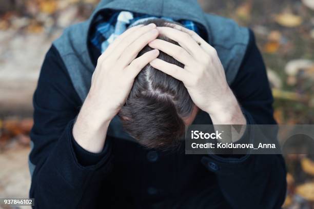 Young Man Covers His Face With His Hands In Grief Stock Photo - Download Image Now - Shock, Emotional Stress, Men