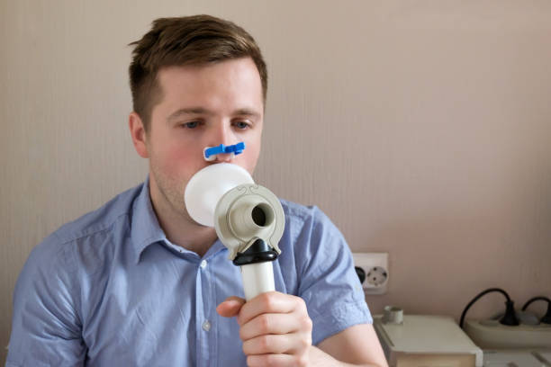 Young man testing breathing function by spirometry Young man testing breathing function by spirometry. Take care about health. easy test stock pictures, royalty-free photos & images