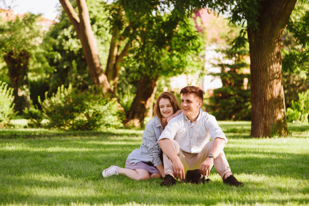 istock Couple sitting on green grass 937848990