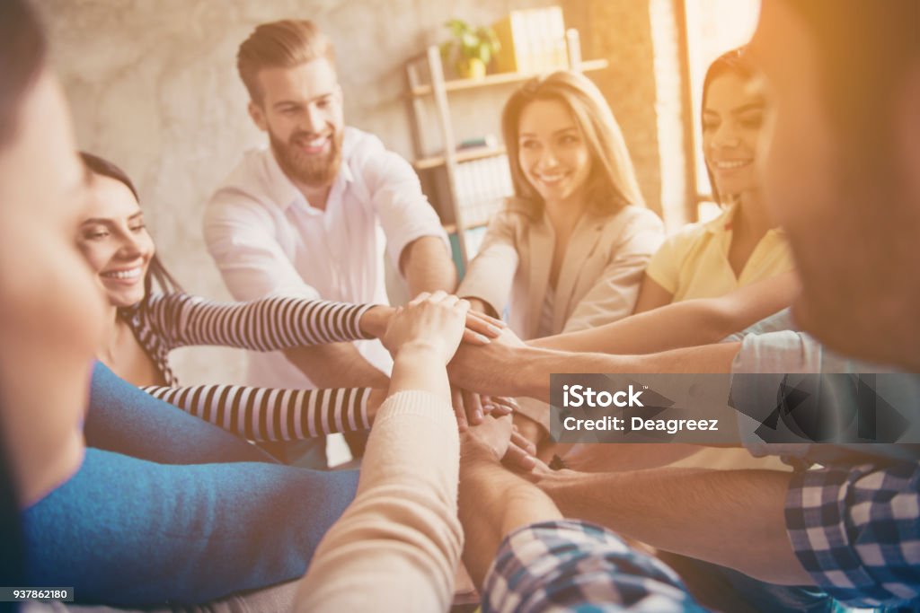 Conception de teambuilding réussi. Recadrée gros plan photo d’un partenaire qui met les mains sur le dessus de l’autre au poste de travail, porter des vêtements décontractés, souriants - Photo de Travail d'équipe libre de droits