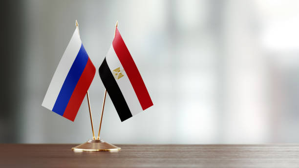 Russian And Egyptian Flag Pair On A Desk Over Defocused Background