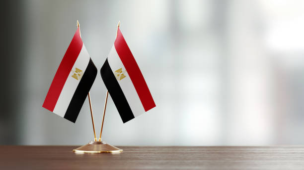 istock Egyptian Flag Pair On A Desk Over Defocused Background 937871402