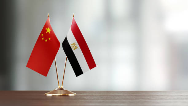 istock Chinese and Egyptian Flag Pair On A Desk Over Defocused Background 937874074