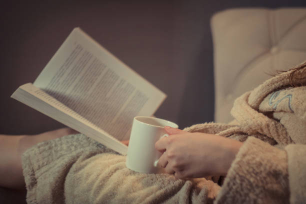 istock Cozy night with book and cup of tea. 937874570