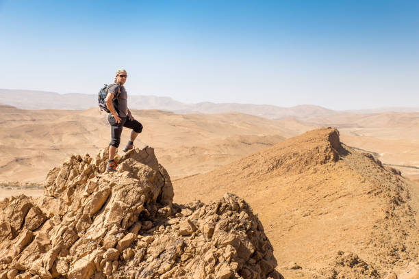 istock Backpacker tourist standing desert mountain cliff ridge edge landscape. 937877864