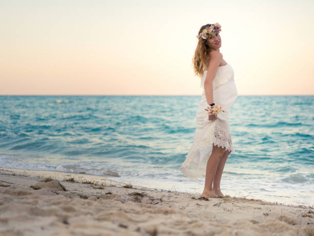 istock Pregnant woman at the beach 937880730