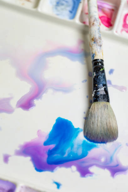 istock Paintbrush on Watercolor Palette Mixing Paint 937880900
