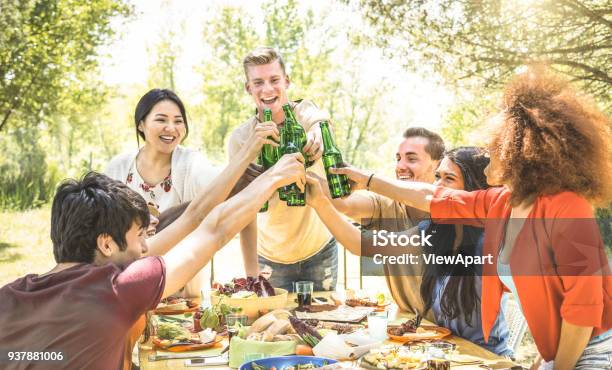 Young Multiracial Friends Toasting At Barbecue Garden Party Friendship Concept With Happy People Having Fun At Backyard Bbq Summer Camp Food And Drinks Fancy Picnic Lunch Focus On Beer Bottles Stock Photo - Download Image Now