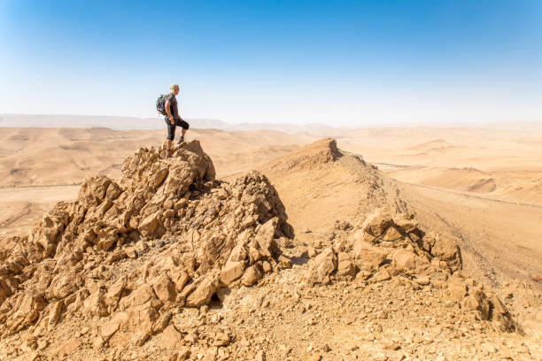 istock Backpacker tourist standing desert mountain cliff ridge edge landscape. 937881024