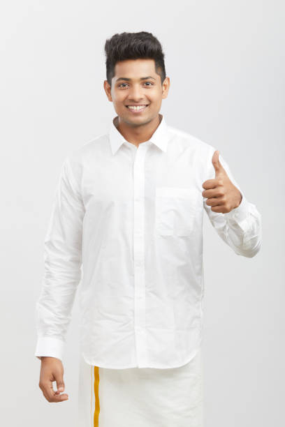 Cheerful handsome south Indian man showing thumbs up on white.