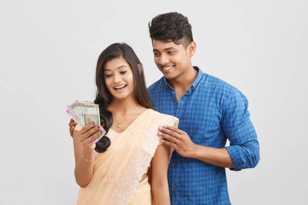 istock Exited cheerful young couple holding Indian currency 937881898