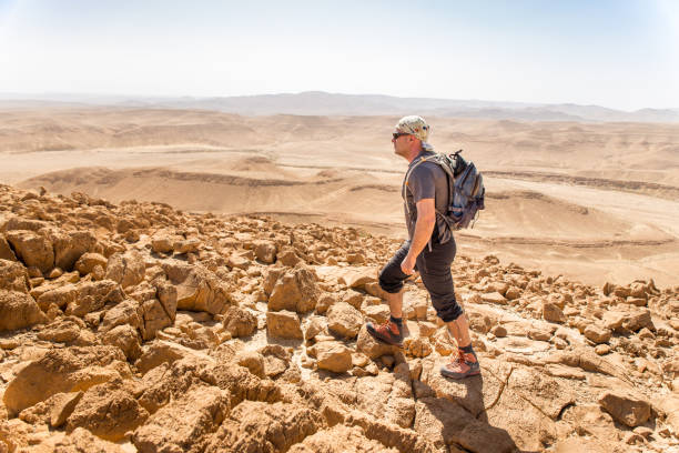 istock Backpacker tourist hiking desert mountain cliff ridge edge landscape. 937882134