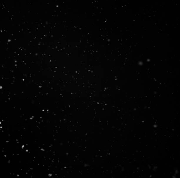 istock Particles of snow on a black background 937887678