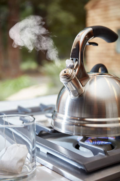 istock Tea Kettle with steam, cup, tea bag 937895182