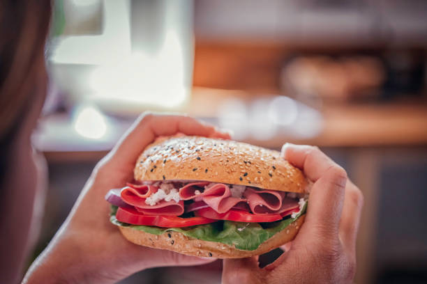 istock Eating Sandwich with Ham, Cucumber, Tomato and Salad 937898924