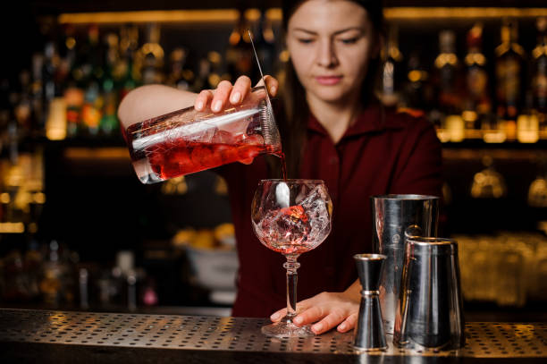istock Bartender girl pouring a delicious red cocktail 937902120