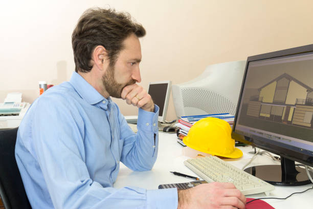 ingeniero sentado delante del ordenador en su oficina - drafter fotografías e imágenes de stock