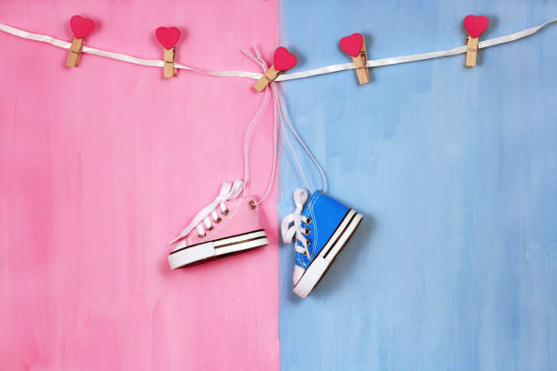 Baby sneakers on pink and blue background, baby shower concept stock photo