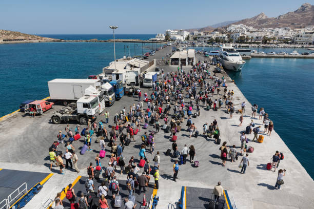 乗客と車は、ギリシャ ナクソス港で船から下船します。ナクソスは毎年多くの観光客が訪れる美しいキクラデス島です。 - motor vehicle outdoors crowd landscape ストックフォトと画像